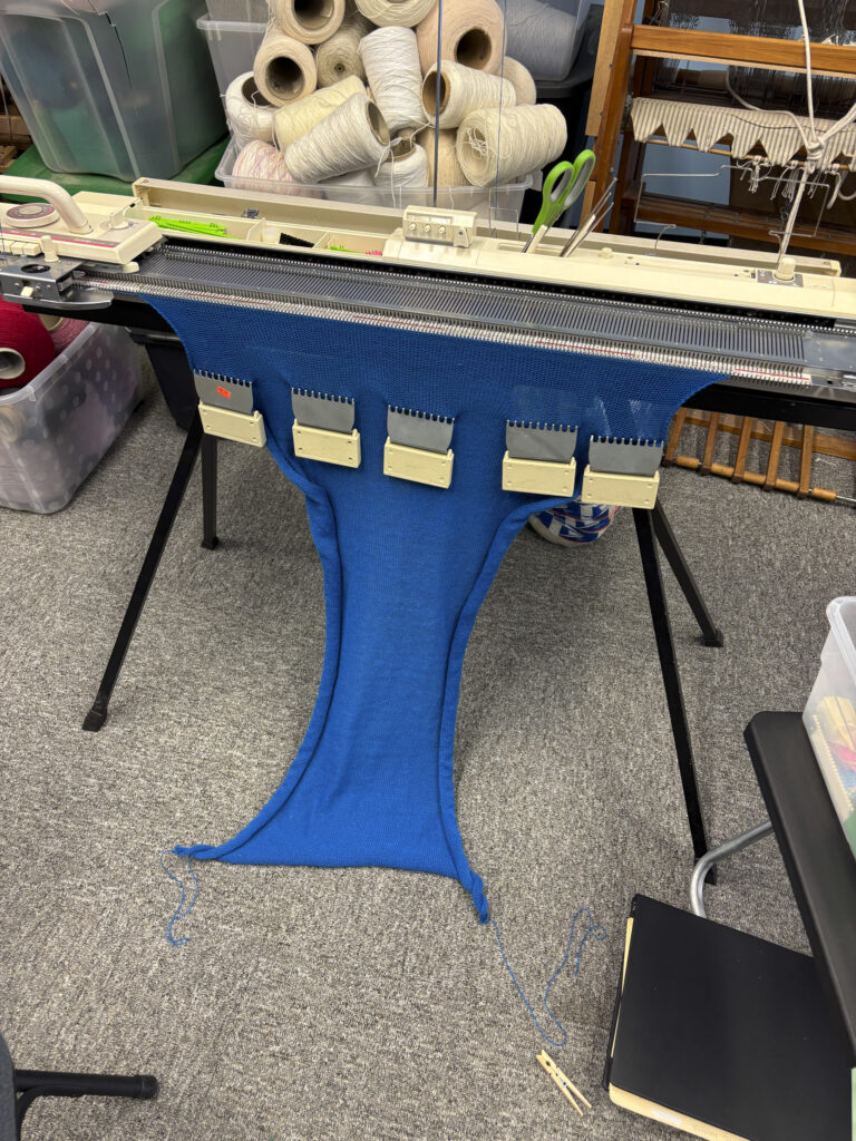 flat bed knitting machine with blue knitted fabric