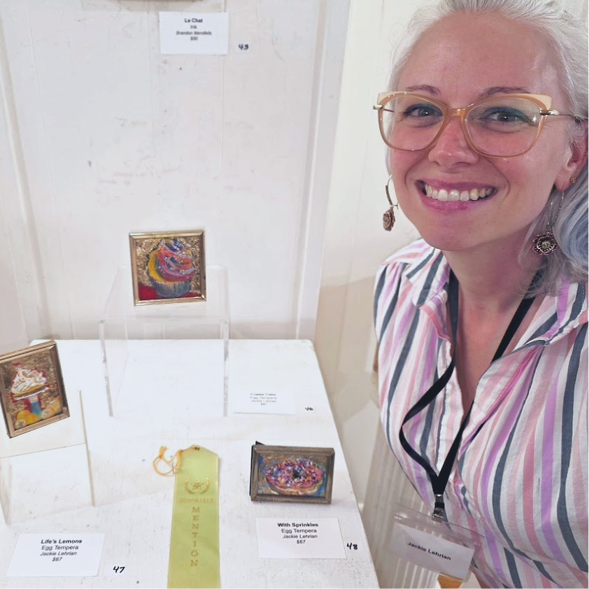 Three small framed pieces of art with a woman pictured on the righ side of the image. An award ribbon in is the center of the artworks.